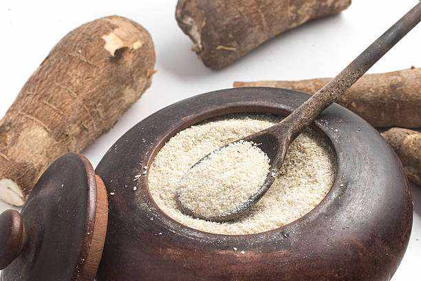 Arrowroot (Toloma) from Kalinago Territory shown as pale cream powder in a dark wooden bowl with a spoon