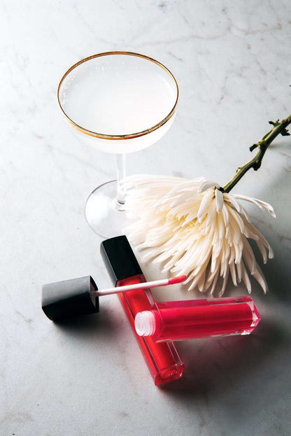 Lip Gloss from Dazzle Me in vivid red with a clear tube, black cap and pink-tipped applicator